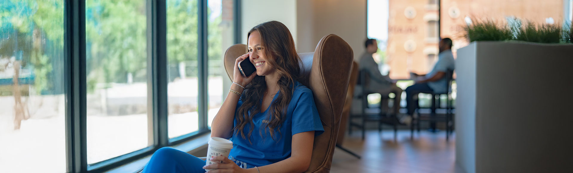 woman talking on phone, smiling, in a healthcare setting.
